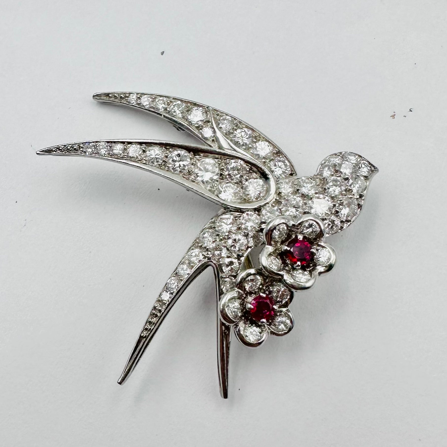 Broche "Oiseau posé sur deux fleurs" en or blanc et platine