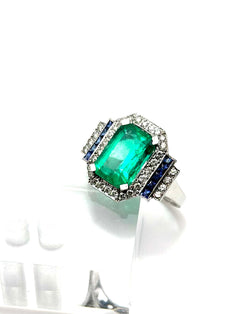 Bague Entourage en or blanc, émeraude, saphirs et diamants