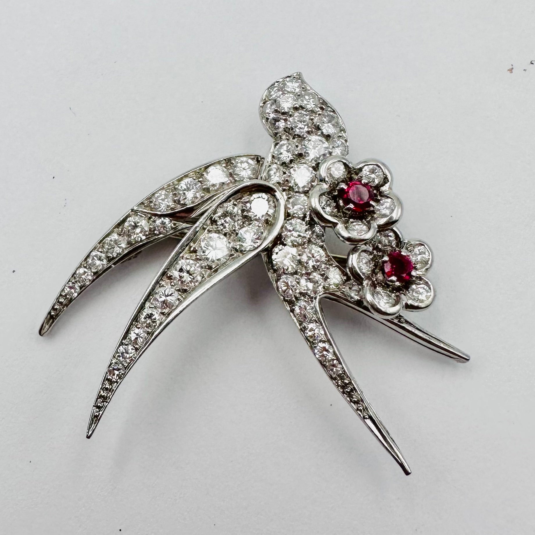 Broche "Oiseau posé sur deux fleurs" en or blanc et platine
