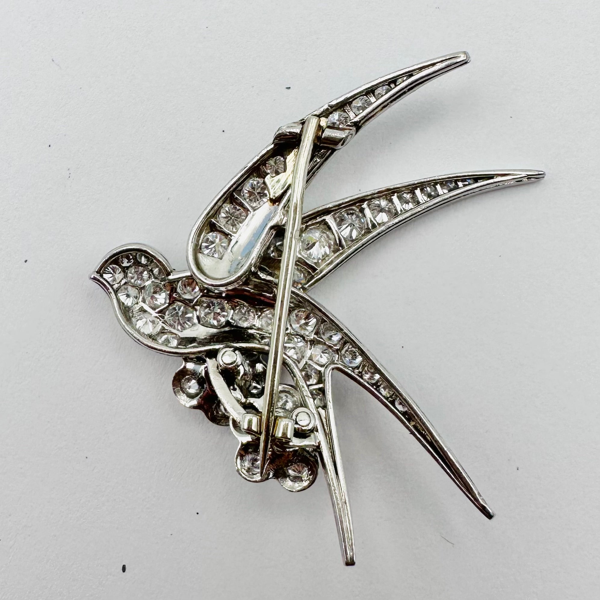 Broche "Oiseau posé sur deux fleurs" en or blanc et platine