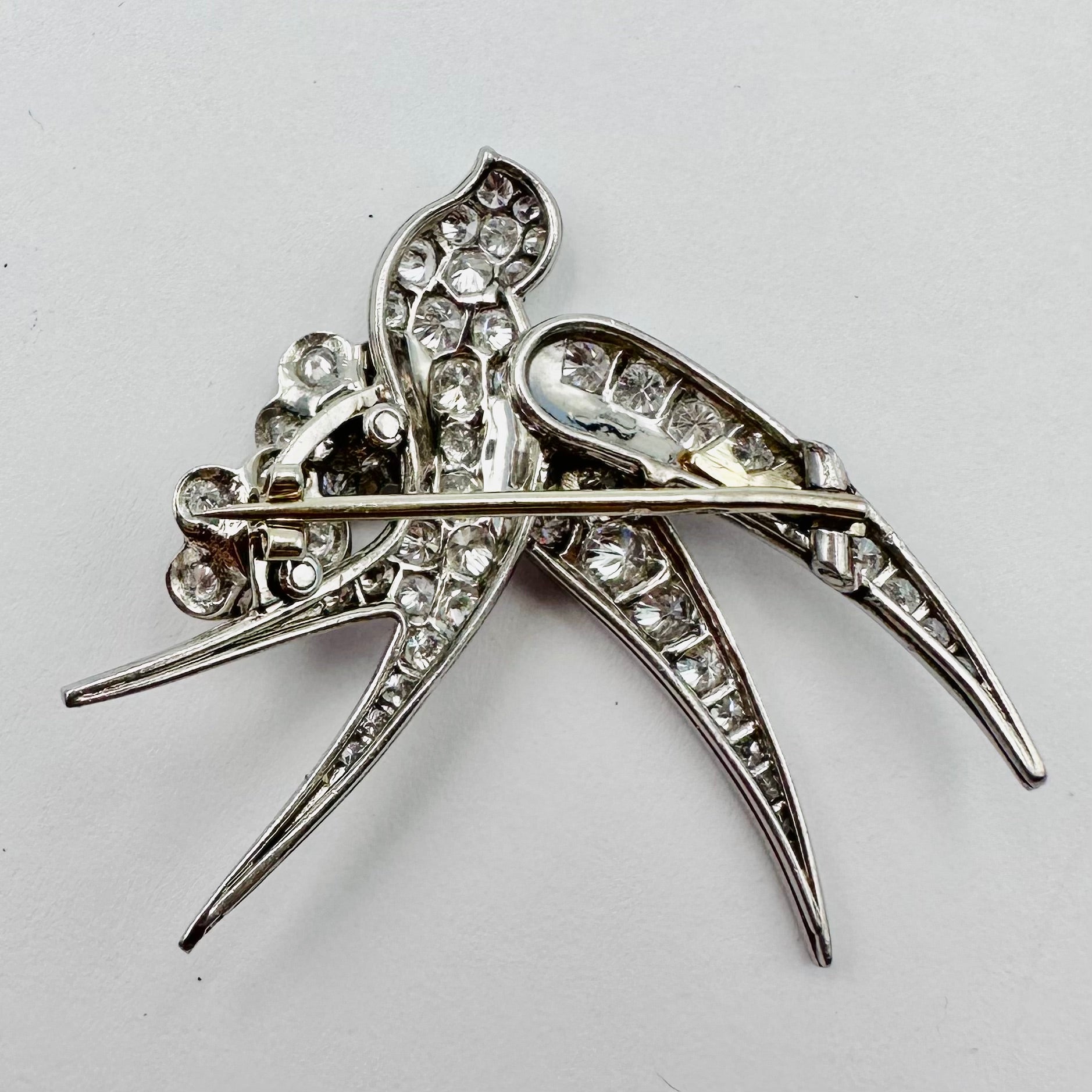 Broche "Oiseau posé sur deux fleurs" en or blanc et platine