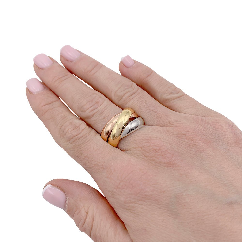 Cartier Trinity ring in yellow, rose and white gold worn on a hand.