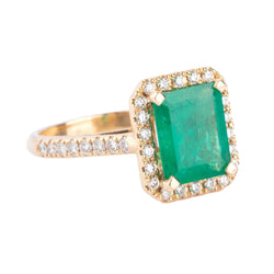 Bague en or jaune ornée d'une émeraude entourée de diamants - Castafiore