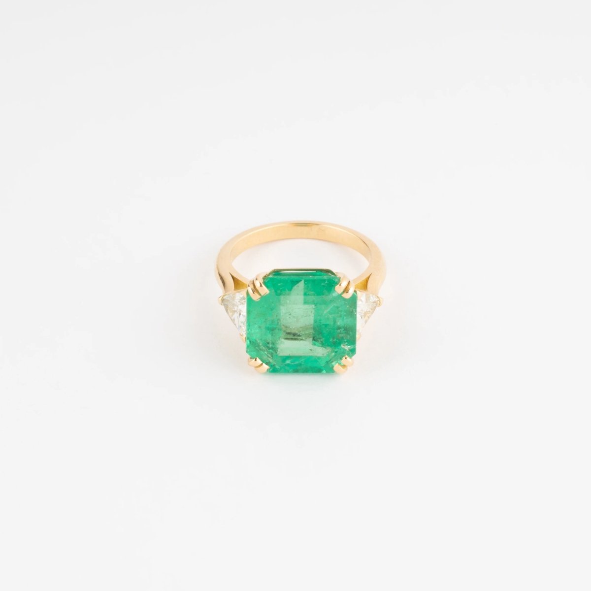 Bague en or jaune ornée d'une émeraude taille émeraude épaulé de diamants triangles - Castafiore