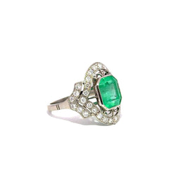 Bague Entourage Art Déco en platine, émeraude et diamants - Castafiore