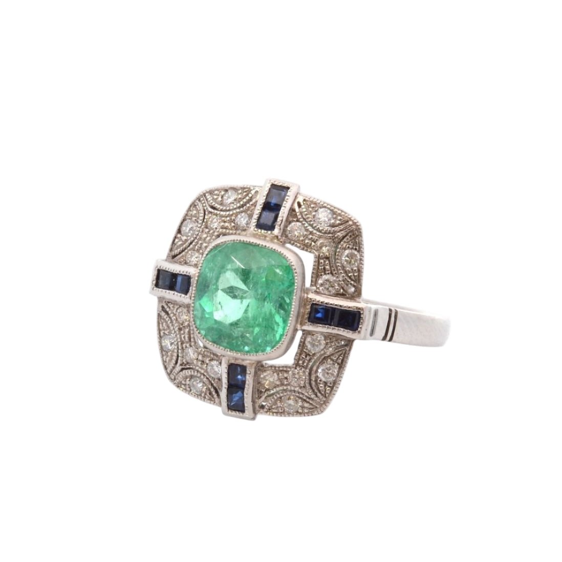 Bague Entourage en platine, émeraude, diamants, et saphirs - Castafiore