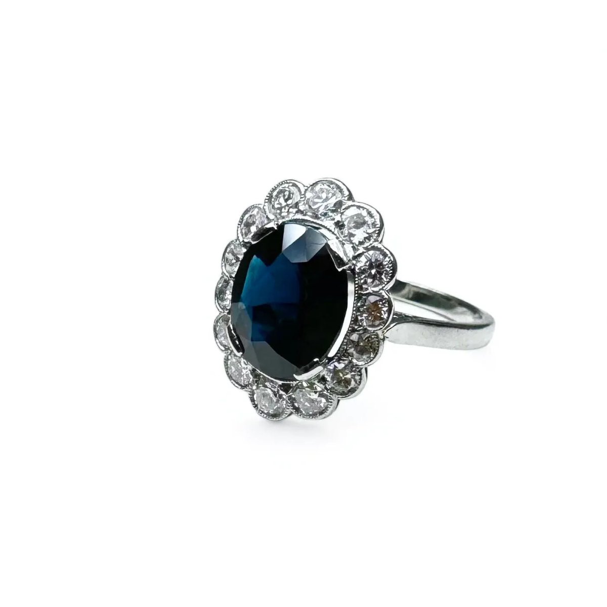 Bague marguerite en platine centrée d’un saphir entouré de diamants. - Castafiore