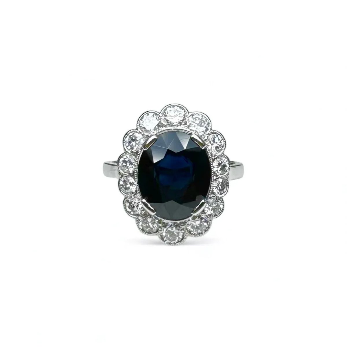 Bague marguerite en platine centrée d’un saphir entouré de diamants. - Castafiore