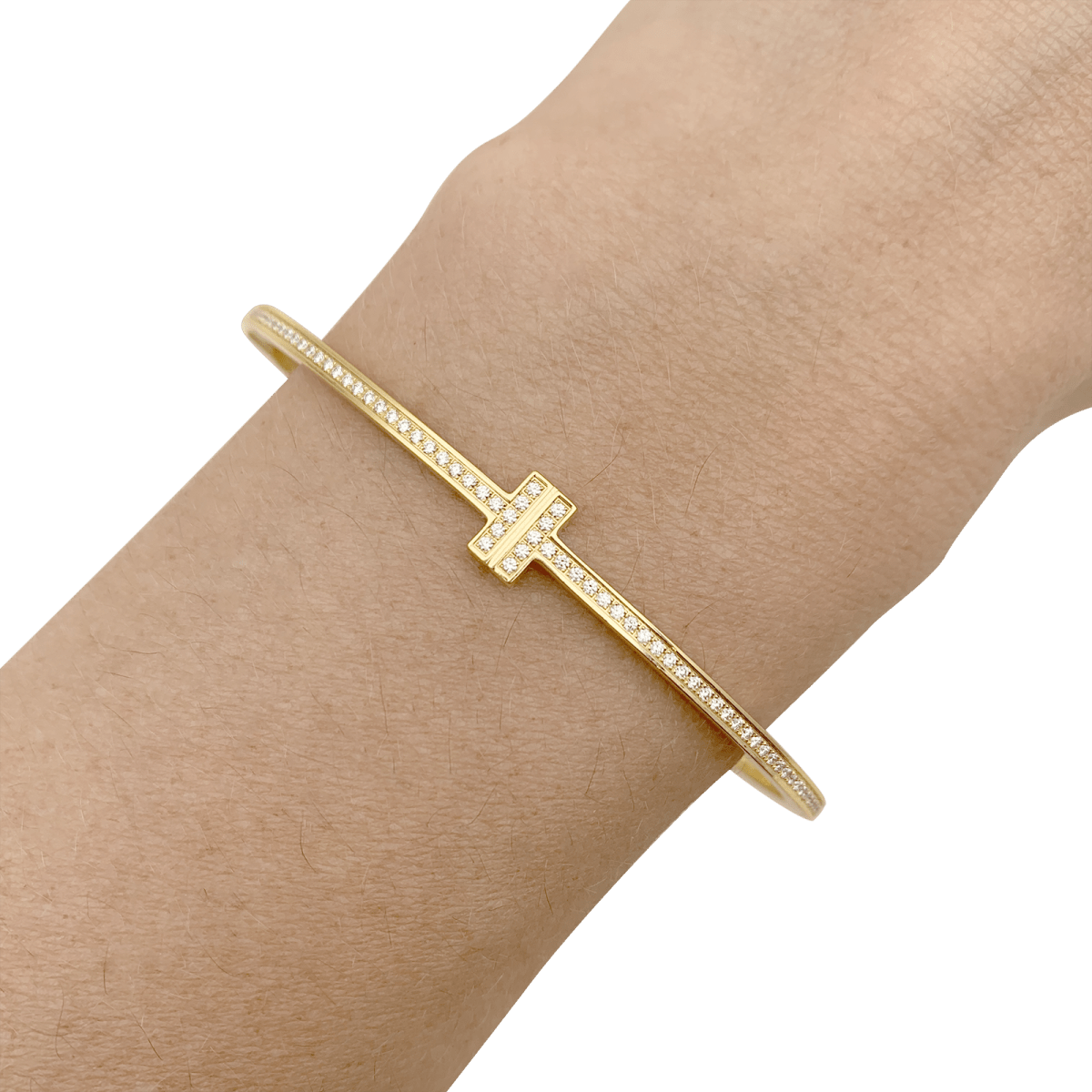Bracelet Tiffany & Co., "Tiffany T" en or jaune et diamants. - Castafiore