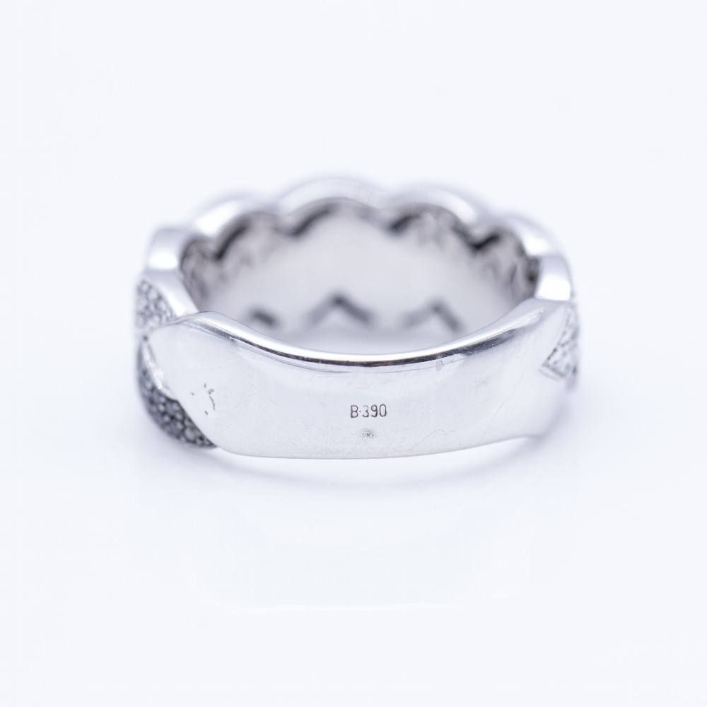 Bague tressée en or blanc avec diamants blancs et noirs.