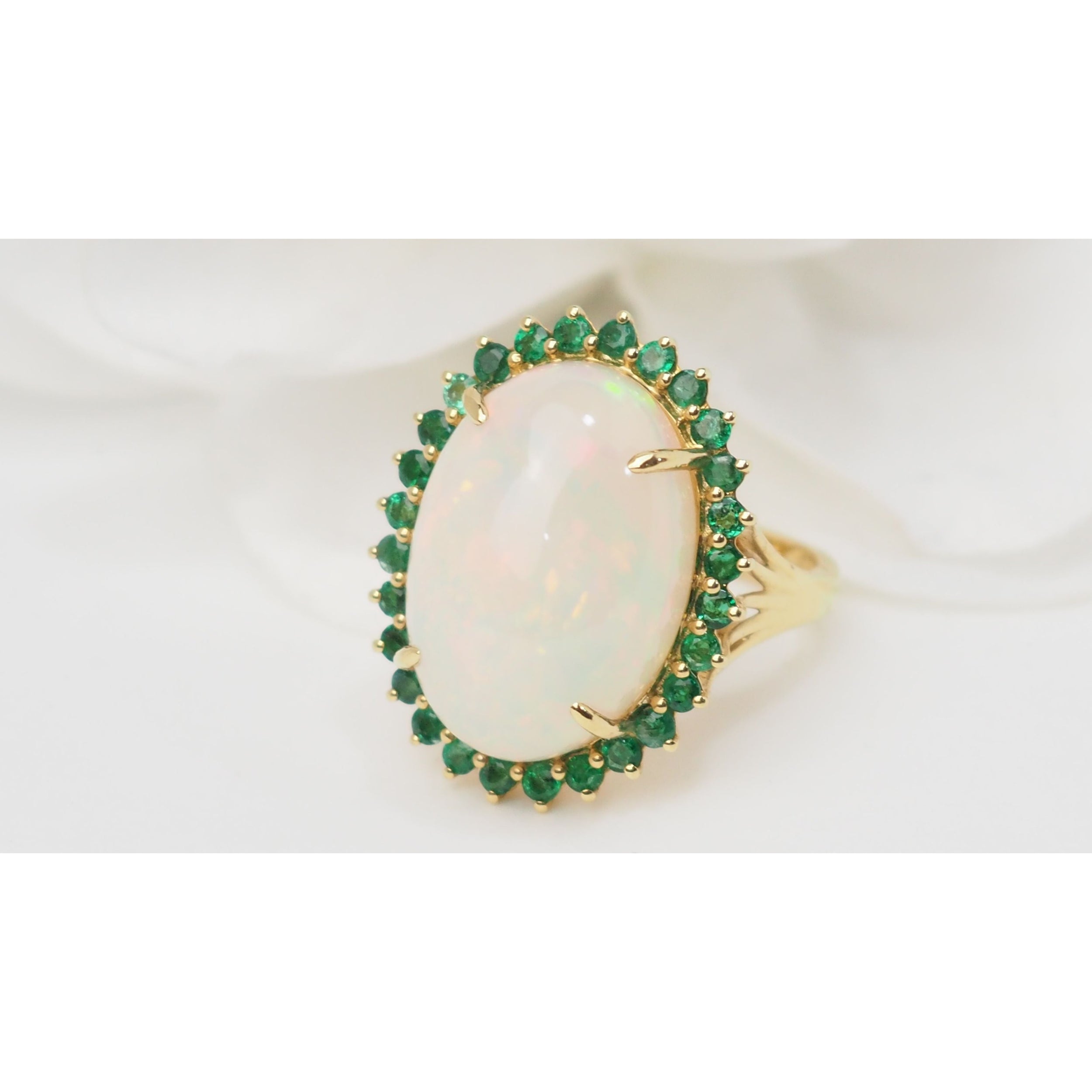 Bague ovale en or jaune, opale cabochon et émeraudes