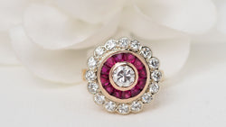 Bague entourage en or jaune, rubis et diamants
